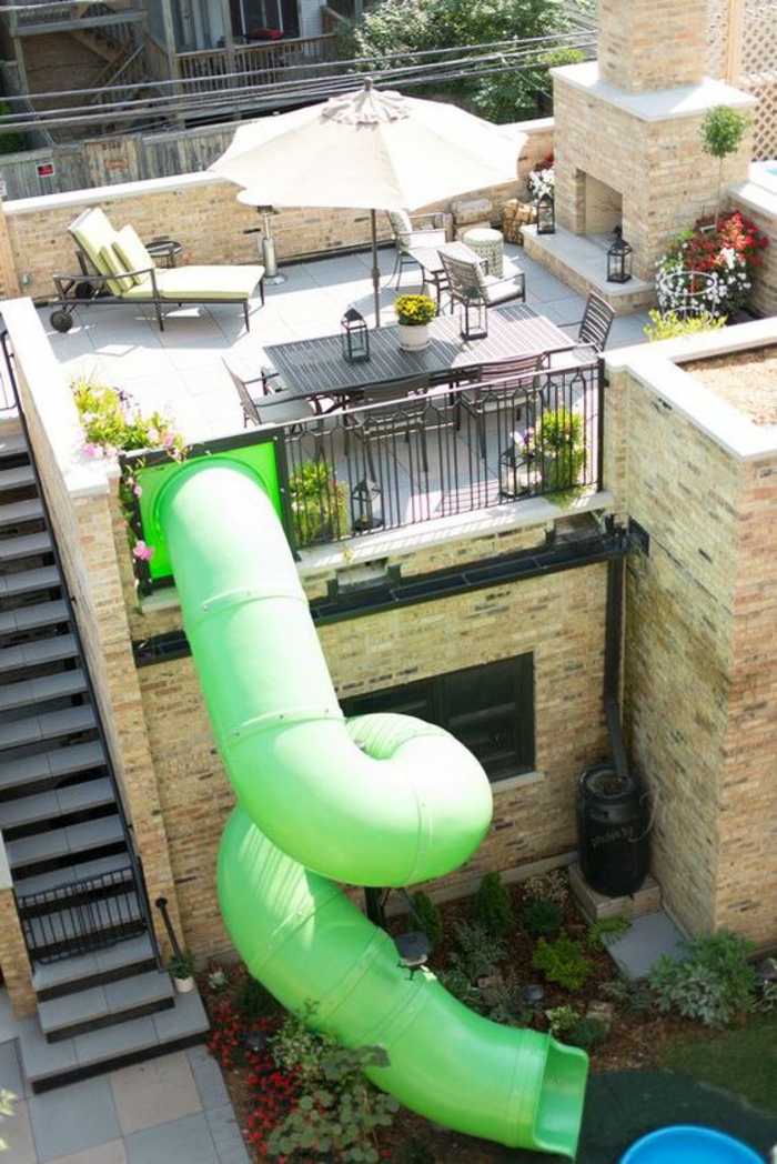 toboggan extrême en plastique verte qui part de la terrasse et descend au niveau inférieur de la maison, decoration jardin terrasse 