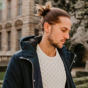 veste bleu fonce pull blanc jeans coiffure messy chignon haut semi