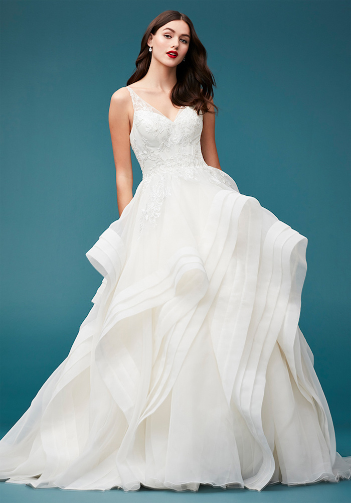 robe de mariée haute couture avec un top décoré de pierres et une jupe en tulle plissée, cheveux lachés