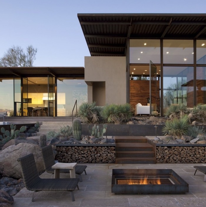 exemple d aménagement extérieur en dalles de béton, chaise longue rotin, brasero moderne, plantes cactus, maison moderne