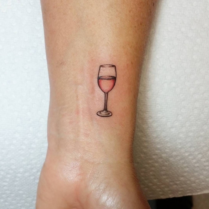 modèle de petit tatouage sur le poignet à design verre de vin rosé, idée dessin en encre pour femme qui aime le vin
