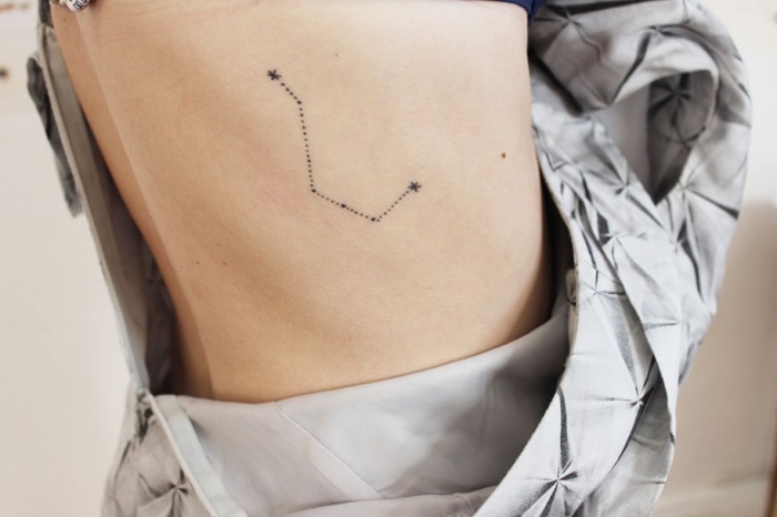 modele de tatouage discret sur le dos à design constellation, dessin en encre sur le corps pour les fans de l'astronomie