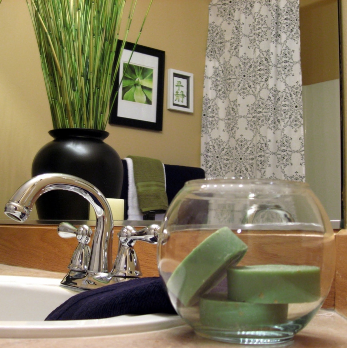 plante pour salle de bain, plante qui absorbe l'humidité, vase noir avec des plantes vertes, lavabo blanc ovale, tableau au cadre noir et tableau au cadre blanc