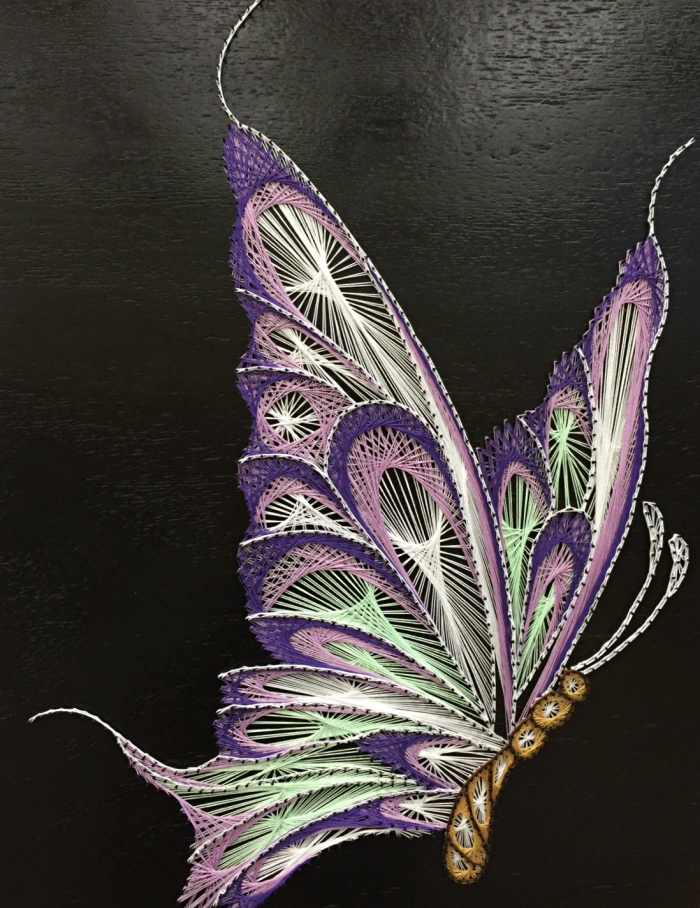loisirs créatifs avec une technique de fabrication créations jolies en fil, modèle de papillon 3D sur planche de bois noire