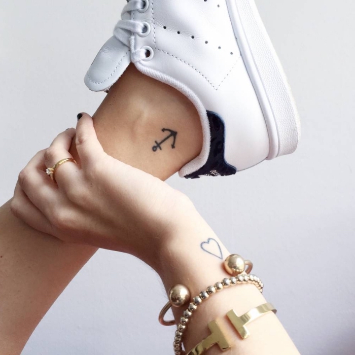 exemple de tatouage femme discret avec un petit ancre sur la cheville et un coeur aux lignes épurées sur le poignet