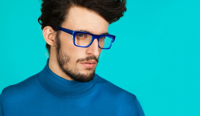 grosse lunette de vue en bleu électrique, homme avec barbe brune et pull moulant en bleu, lunette hipster, lunette tendance saison actuelle, look arty 