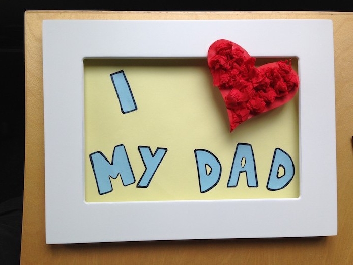 cadre photo blanc avec un fond décoré lettres j aime papa et un coeur en papier de soie rouge, activité fete des peres