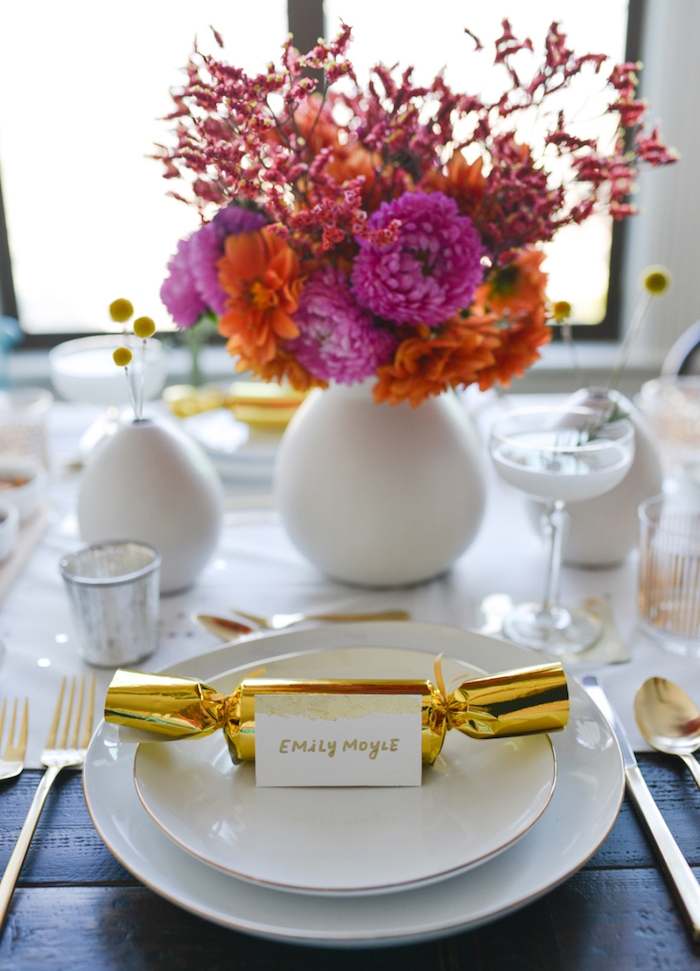 marque place original gourmand en bonbon en enveloppe dorée, chemin de table blanc, centre en bouquet de fleurs, accents jaunes et or