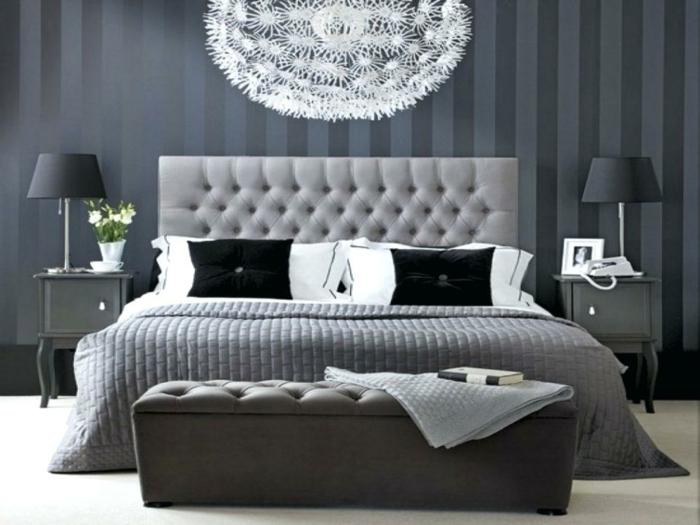 chambre en gris et blanc décorée d'un grand plafonnier blanc, plaid de lit gris, deux chevets noirs