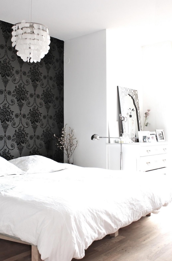 créez un mur d'accent unique dans la chambre à coucher qui fait office de tete de lit deco, un joli contraste entre l'intérieur blanc et le papier peint intissé noir