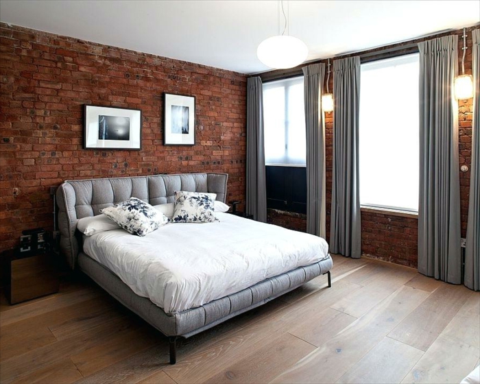 chambre en gris, blanc et mur en briques, rideaux gris, sol en bois, appliques murales