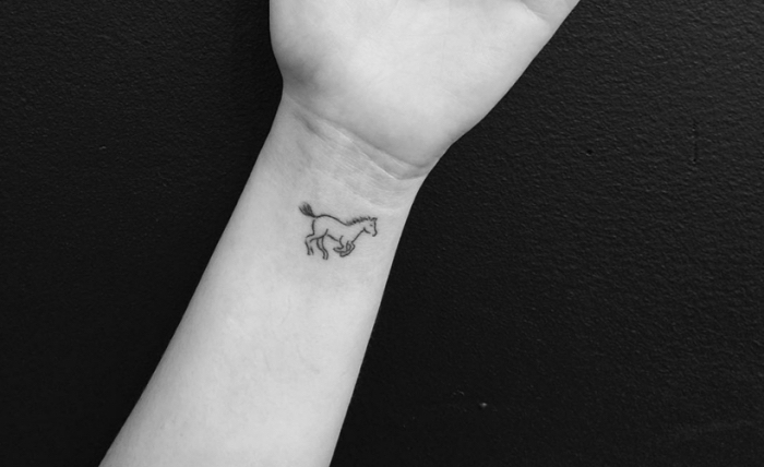petit dessin en encre à design animal à tatouer sur le poignet, tatouage avec mini cheval sur la main pour femme ou homme
