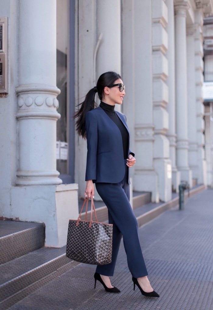 exemple de tailleur pantalon femme chic de couleur bleu foncé porté avec un pull élégant en noir et chaussures à petits talons