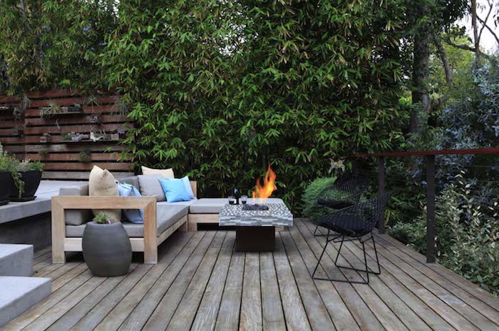 idée terrasse bois avec canapé bois, table basse avec braséro intégré, clôture bois végétalisée