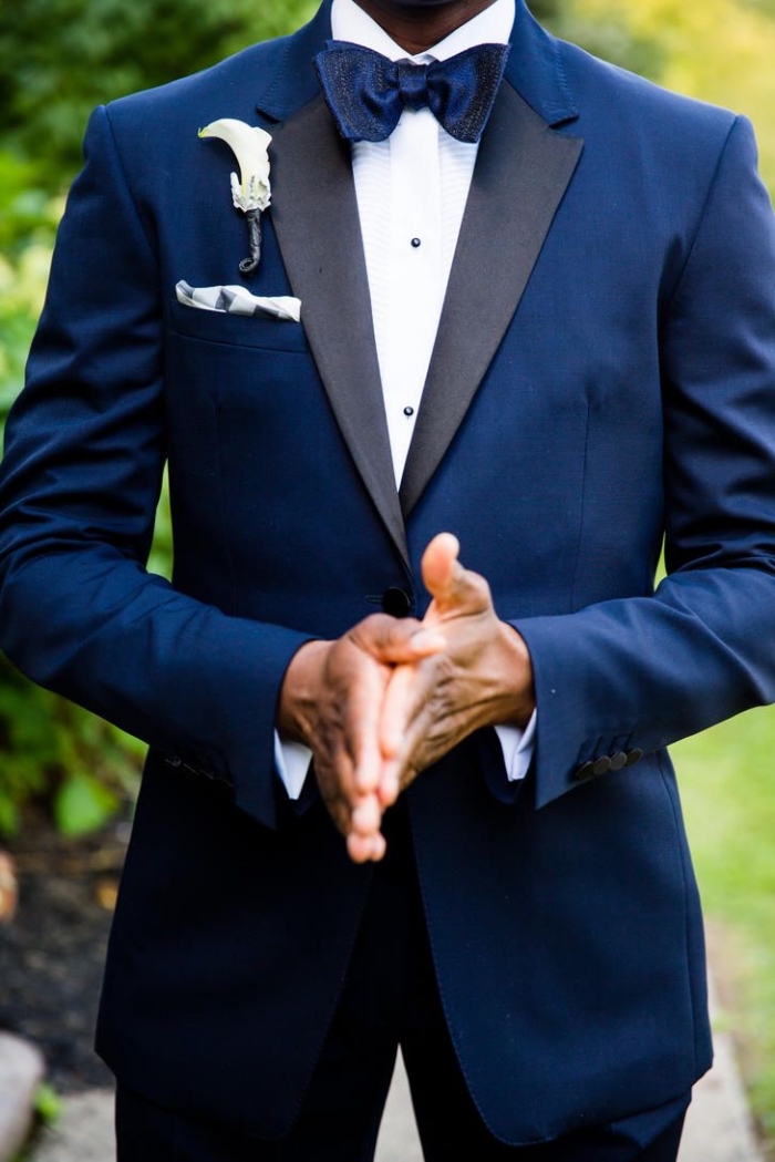 tenue mariage homme formelle en smoking bleu marine avec revers contrasté en satin noir assorti avec un noeud papillon satiné
