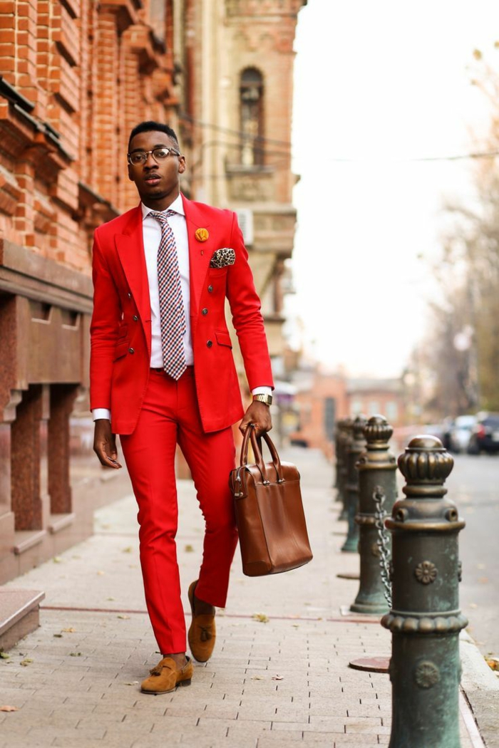 look d'affaires tenue homme chic en rouge avec des chaussures marron clair, chemise blanche, cravate rouge et noir, sac porte-documents en marron, mouchoir pochette en soie noir et jaune 