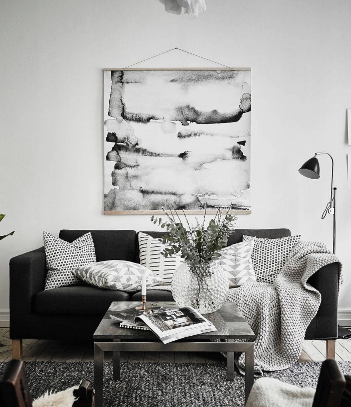 esprit minimaliste avec objets décoratifs en blanc et noir pour une ambiance cozy, déco de salon aux murs blancs avec meubles et accessoires gris