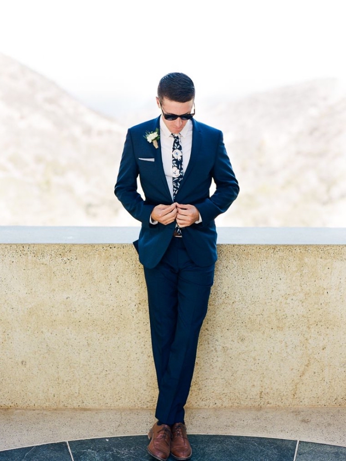 un costume bleu marine bien taillé decoupe moderne combiné avec une cravate imprimé floral d'esprit seventies, silhouette élégante en tenue homme mariage sur-mesure