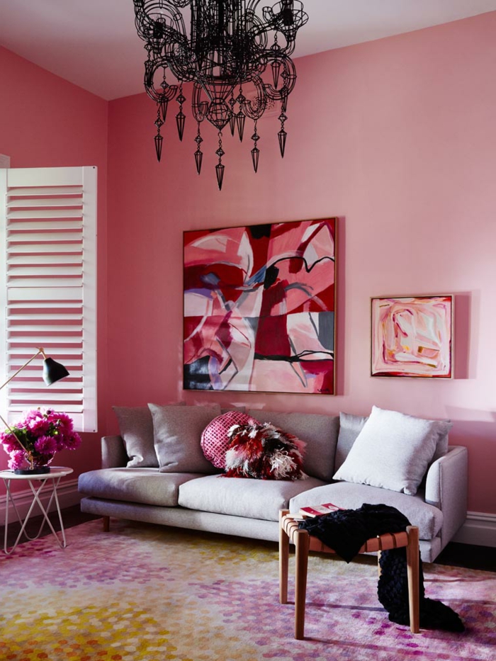 tableau peinture, plafonnier original, sofa gris, mur rose, table basse blanche, fenêtre vintage, tapis multicolore
