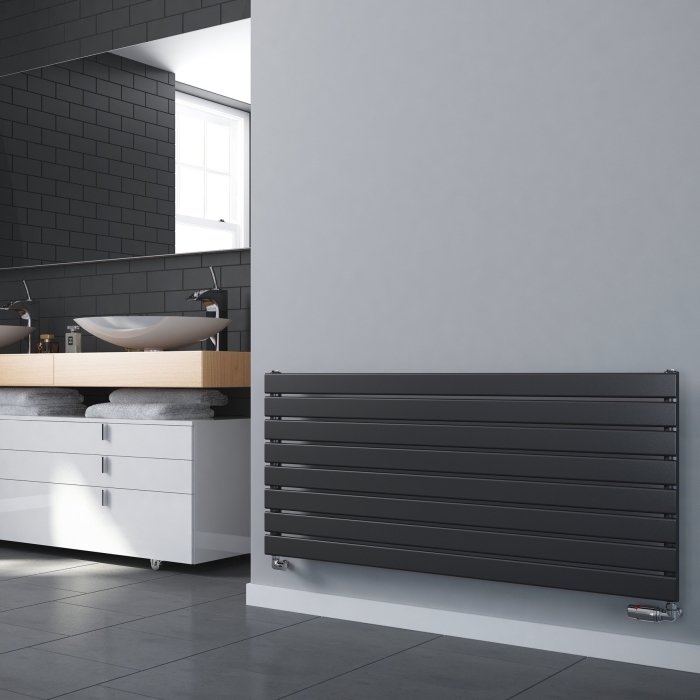 modèle de radiateur salle de bain de couleur gris foncé sur un pan de mur gris clair, carrelage design briques en gris foncé