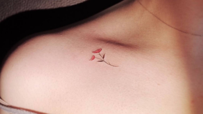 tattoo à design petits fleurs de couleur rouge réalisé sur la clavicule femme, modèle de dessin minimaliste sur le corps