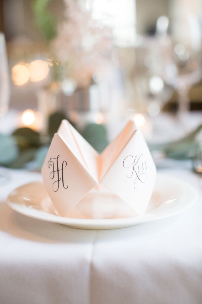 jolie décoration de table de mariage sur le thème de l'origami à réaliser soi-même, un marque-place en cocotte en papier en avec les initiales des mariés