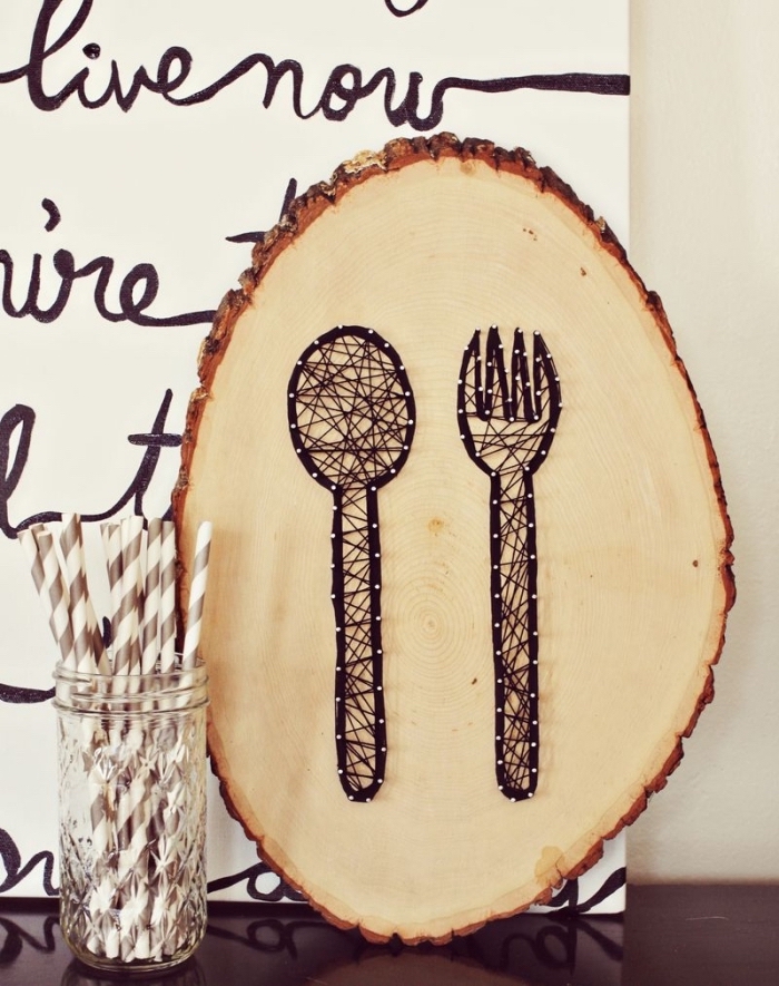 aménagement coin de cuisine avec panneau blanc à lettres noires et un tableau de bois à dessins cuillère et fourchette
