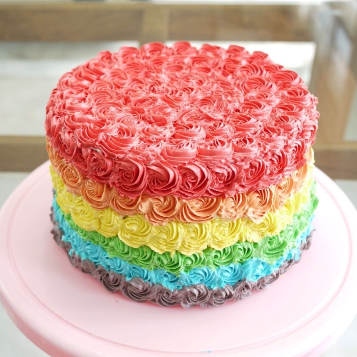 recette de layer cake original aux couleurs de l'arc-en-ciel avec une jolie décoration de roses en glaçage