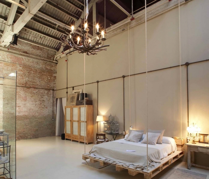 deco industrielle chic dans un loft, lit en palette suspendu, armoire industrielle de bois, lustre baroque, ossature apaprente