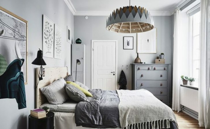 plafonnier et placard gris, lampe noire, coussins gris, jeté de lit gris, plancher en bois