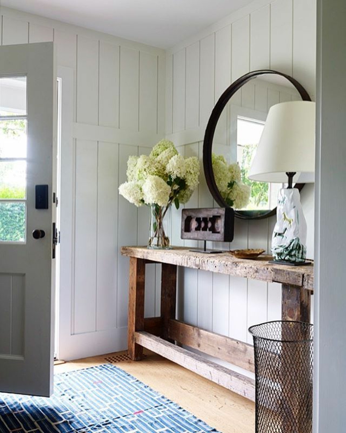 miroir entrée rond encadré, lambris mural blanc, bouquet de pivoines, table en bois brut
