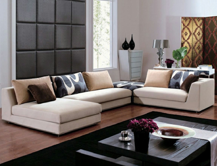 jolie idée pour la décoration intérieure salon, canapé d'angle couleur gris clair, tapis rectangulaire noir, déco murale de salon