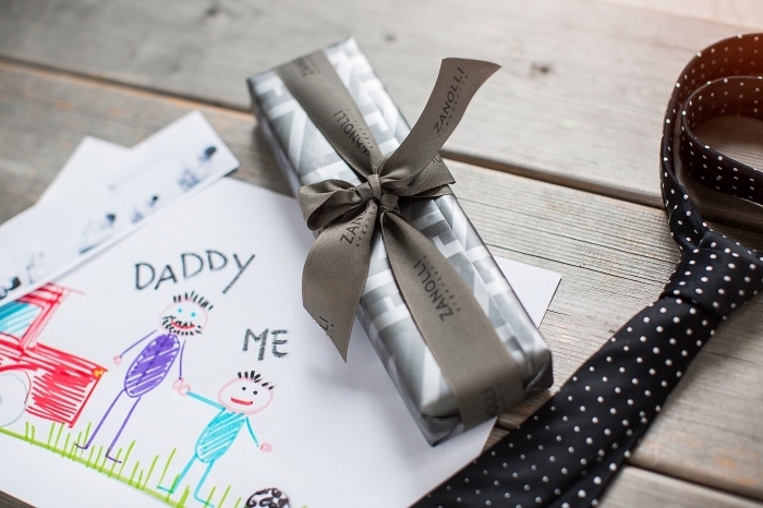 exemple de cadeau pour papa fait main avec une carte voeux à dessin famille, petite boîte rectangulaire emballée en gris