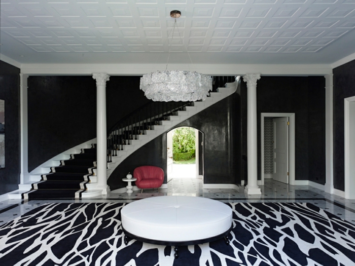 table ronde blanche, sol en noir et blanc, escalier tournant classy, grand plafonnier blanc