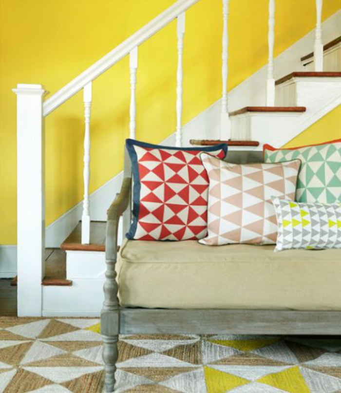 escalier en bois et blanc, mur peint jaune, coussins déco graphiques, tapis graphique