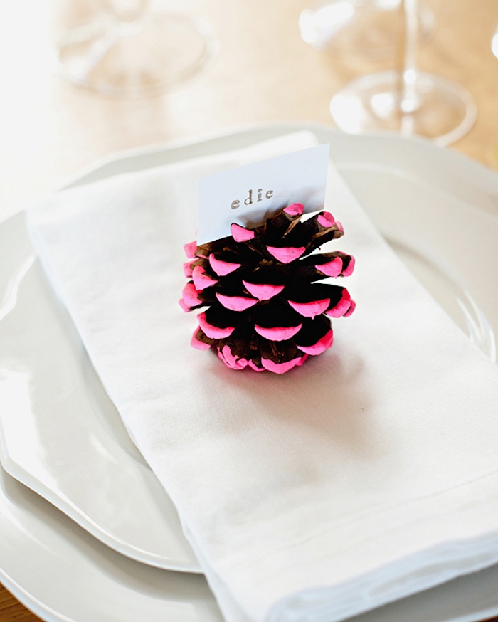 pomme de pin décorée de peinture rose, et etiquette prénom simple, assiettes blanches, deco de table mariage simple