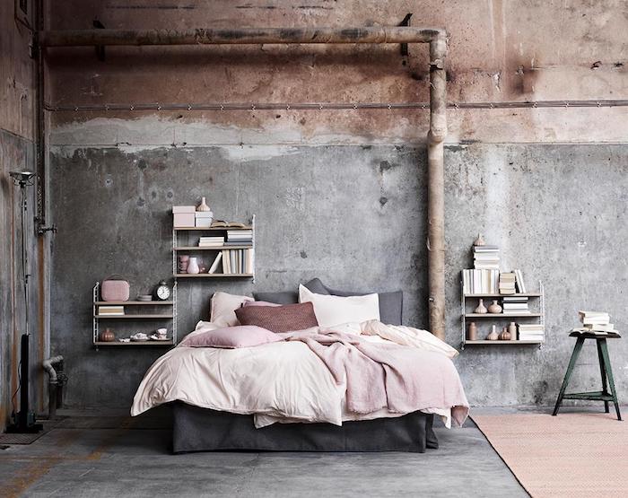 comment faire une etagere industrielle en bois, mur effet béton, tuyaux apparents, linge de lit rose et blanc sur un lit gris, sol gris