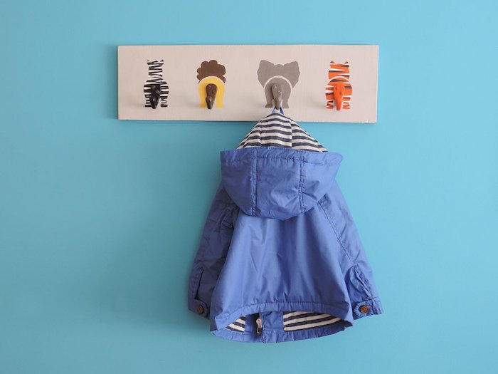 porte manteau mural original pour la chambre à coucher planche de bois avec motif animaux sauvages, mur bleu et blouson enfant