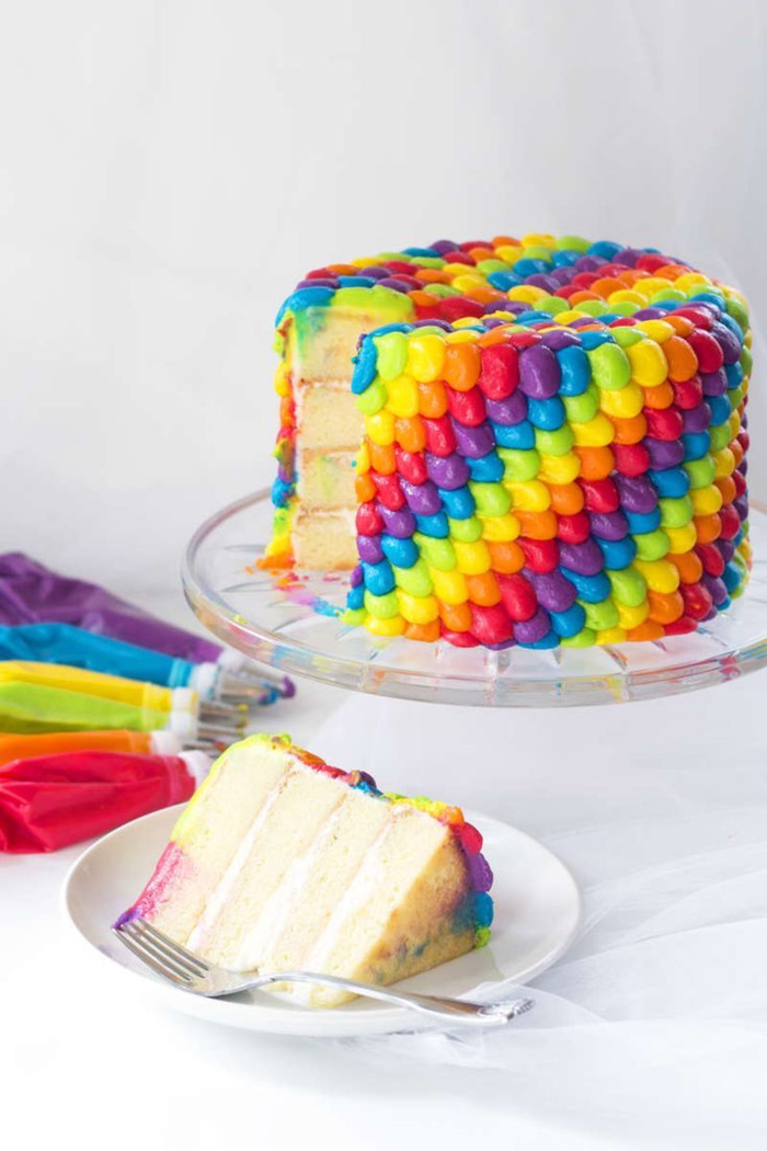 recette de layer cake à la vanille sans gluten, au glaçage aux couleurs de l'arc-en-ciel, décorée à la poche à douille 