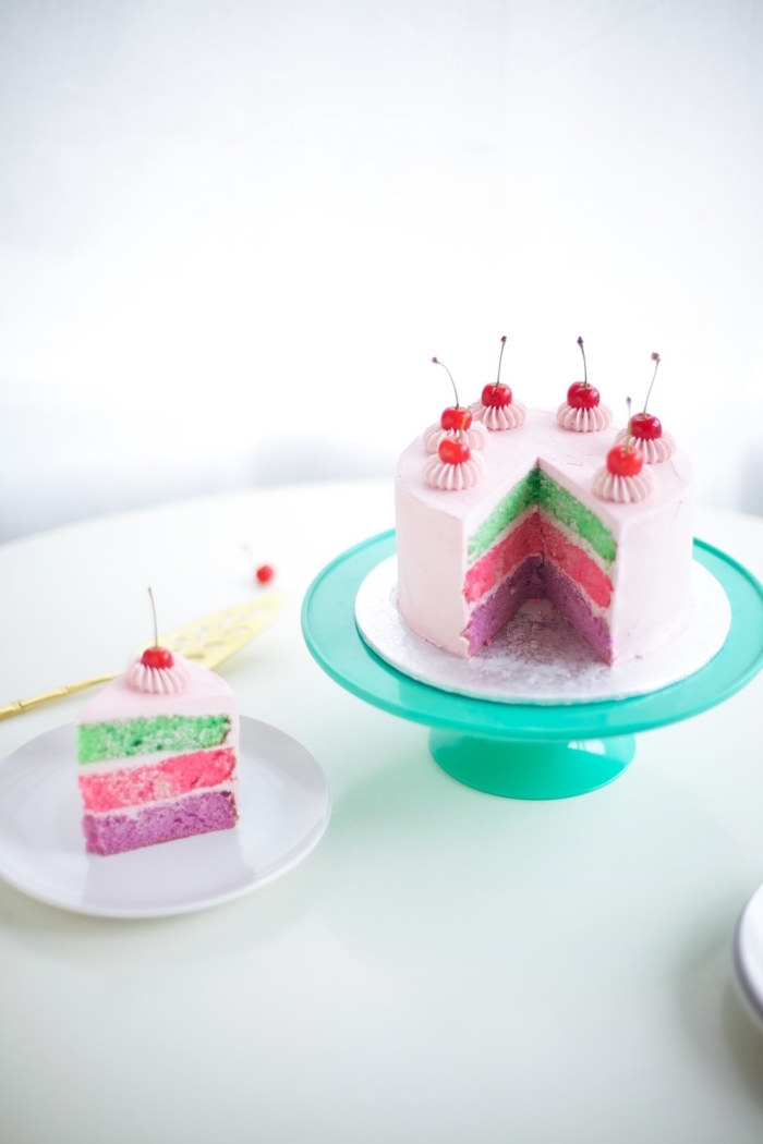 joli gâteau arc en ciel au look vintage à base de génoises de trois couleurs et recouvert de glaçage rose