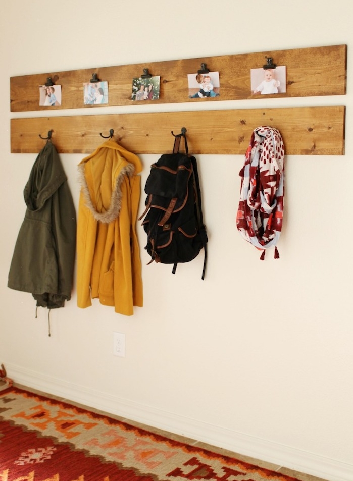 planches de bois clair avec des accroches metalliques, rangement manteaux et accessoires, deco de photos, tapis coloré