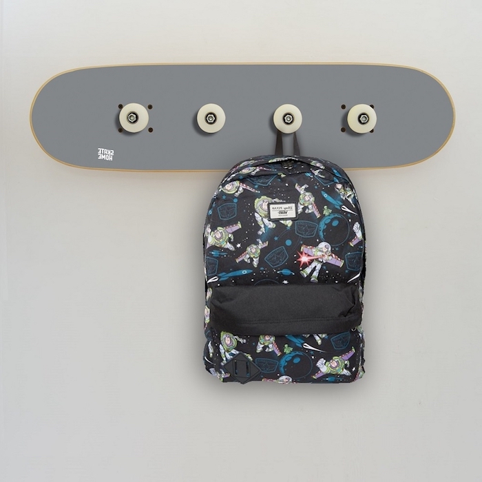 idée de porte manteau mural design en skateboard gris avec des accroches sac à main, mur gris clair