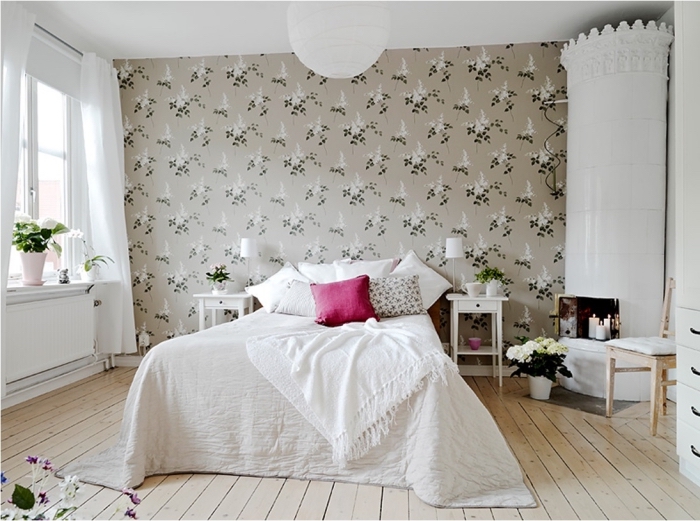 une chambre à coucher au charme vintage avec une tete de lit papier peint à motif vintage floral faisant office de mur d'accent