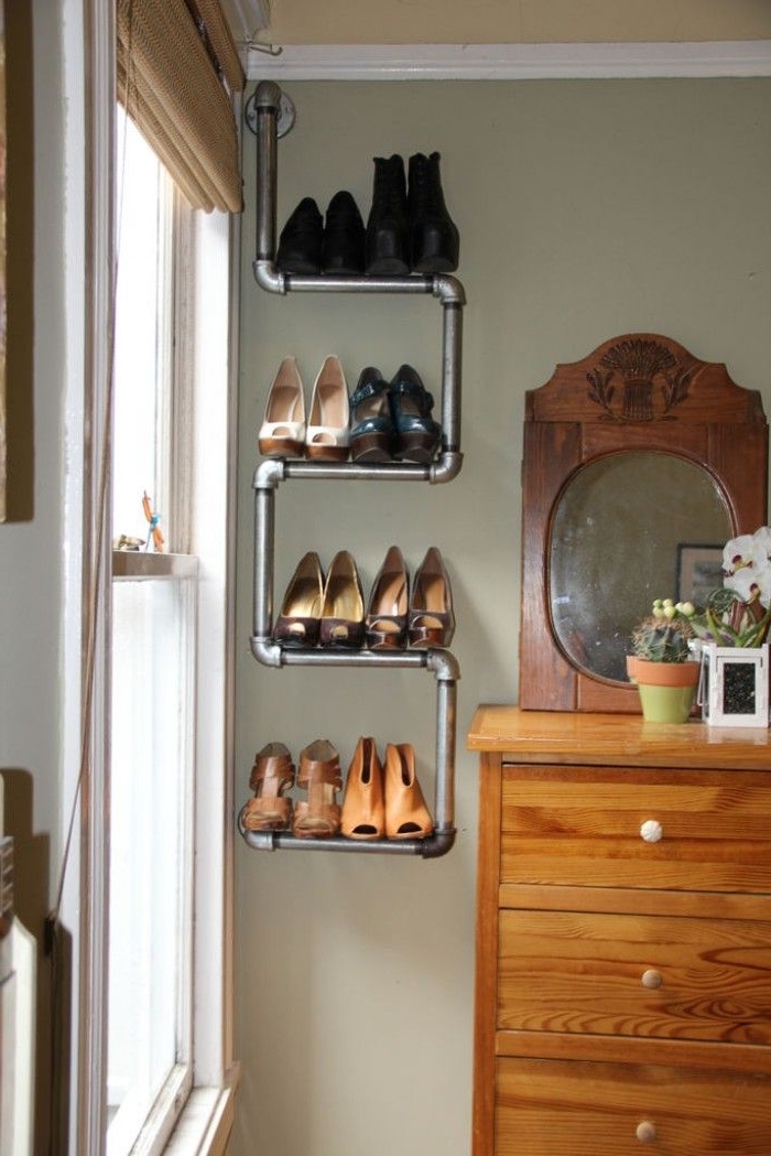 une étagère à chaussure récup à trois niveaux réalisée avec des tuyaux de plomberie, en contraste avec la coiffeuse vintage