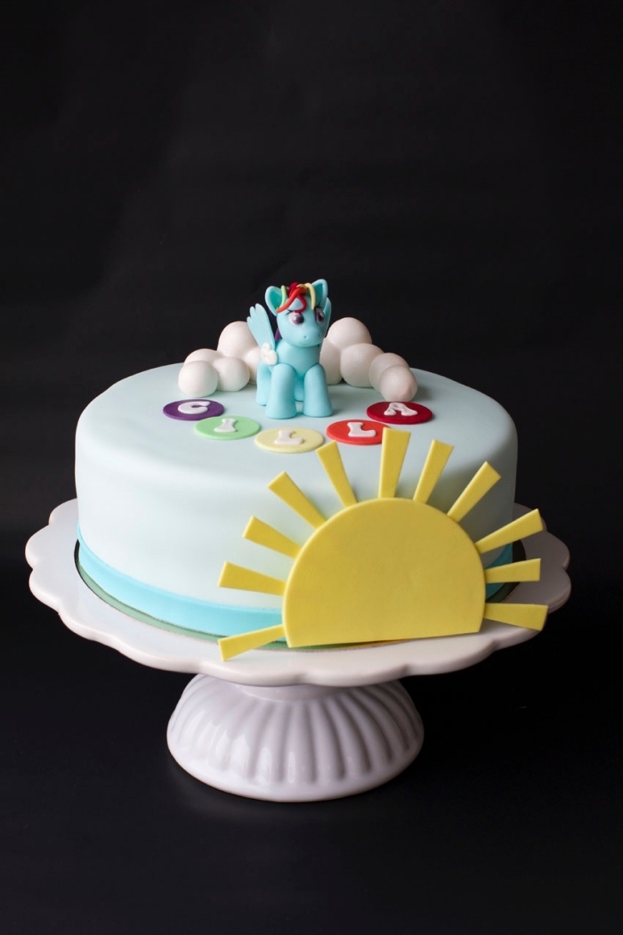 idée de gâteau arc en ciel sur le thème licorne, recouvert de pâte à sucre et décoré avec des modelages en pâte à sucre