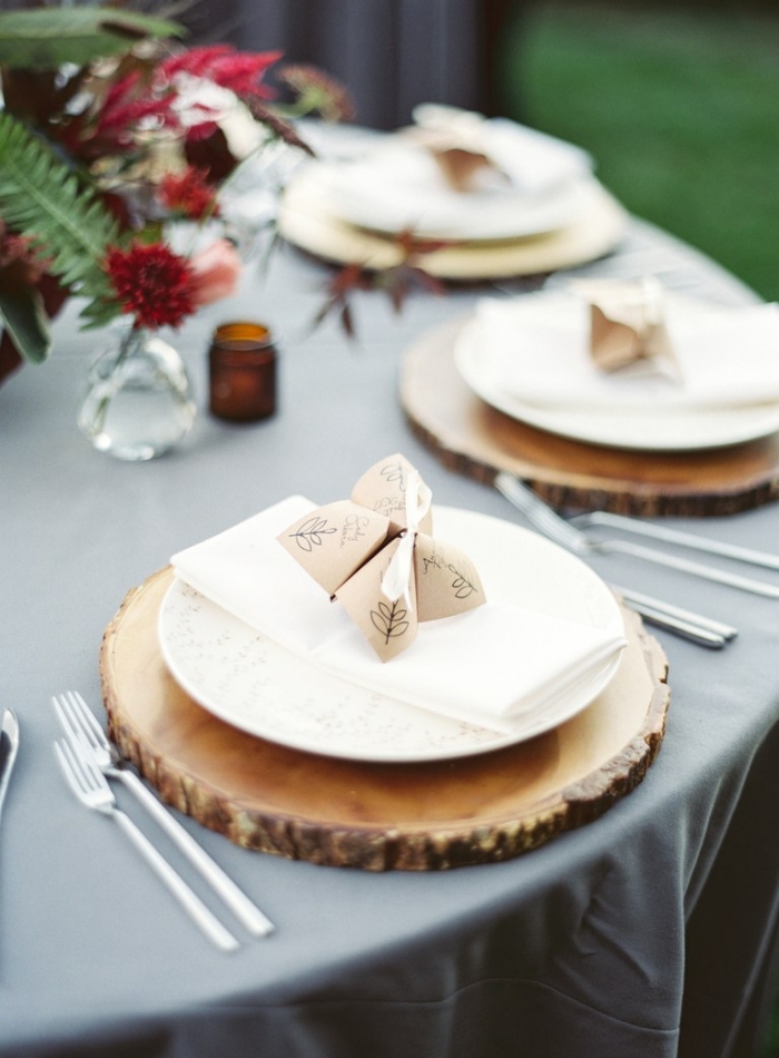 jolie décoration de table de mariage en style rustique avec des sous-assiettes en rondin de bois et marque-places origami, comment faire des cocottes en papier pour la décoration de table