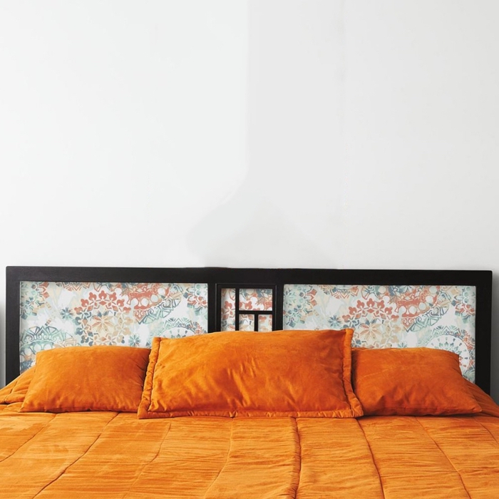 une tete de lit diy en papier peint imprimé encadré à motif abstrait qui contrastie avec le cadre en bois foncé
