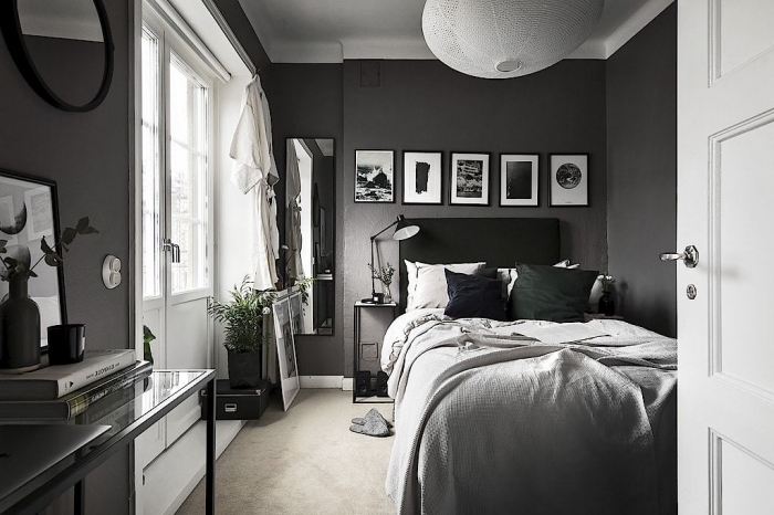 design intérieur dans une chambre à coucher aux murs gris anthracite avec plafond et portes blanches, déco en blanc et noir