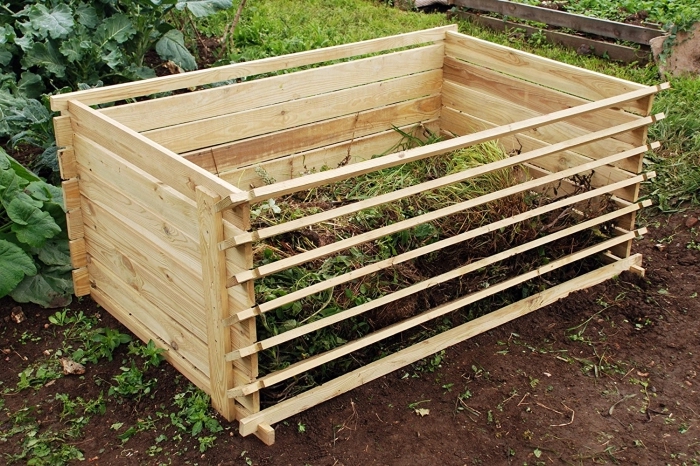 exemple de petit composteur fait main à partir de bois avec mécanisme d'ouverture et aération installé dans le jardin