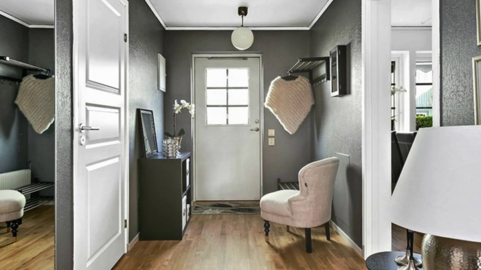 décoration entrée appartement ou maison, sol en bois, chaise blanche, console noire, grand miroir mural